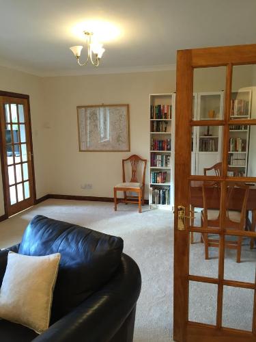 a living room with a leather couch and a chair at Cottage at the Hollow in North Middleton