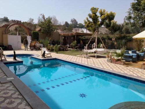 a large swimming pool with blue water in a yard at West Bank luxury villa in Luxor
