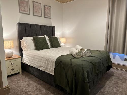a bedroom with a large bed with towels on it at Comfy Stay Near City & Station in Preston