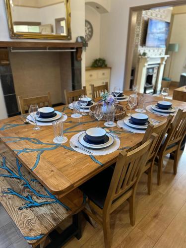 a wooden table with plates and glasses on it at Comfy Stay Near City & Station in Preston