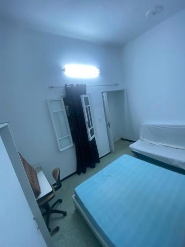 a room with a bed and a blue light at Bouchama's Arabesque house in Mahdia