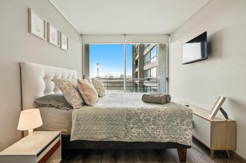a bedroom with a bed and a large window at Apartamento General Mackenna B&E in Santiago