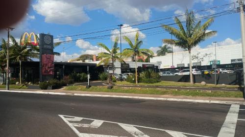 an empty street with a mcdonalds and palm trees at Kitnet central in Franca