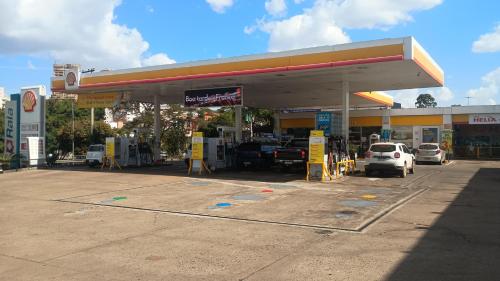a gas station with cars parked in a lot at Kitnet central in Franca