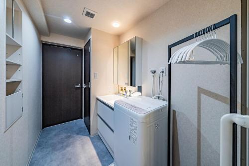 un bagno con lavandino e lavatrice di LABEL 01 Dotonbori Aparthotel ad Osaka
