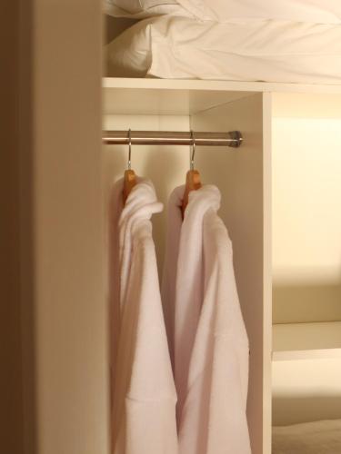 a row of white towels hanging on a rack in a bedroom at Hideaway Falls - Evergreen Cottage in Mapleton