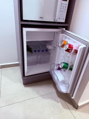 an open refrigerator with drinks inside of it at Guaru Inn Hostel in Guarulhos
