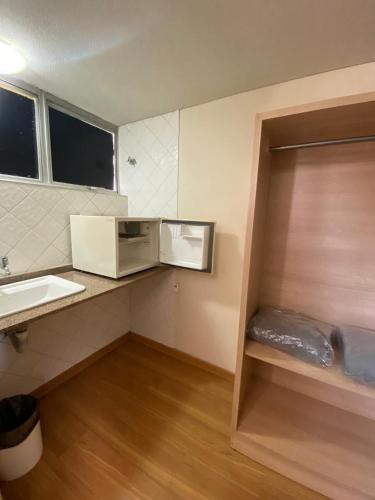 a small bathroom with a sink and a microwave at Hotel Nacional Inn Curitiba Estação Shopping in Curitiba
