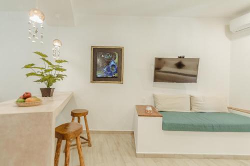 a living room with a couch and a counter with stools at Aldea San Lam - Oasis Of Tulum in Tulum