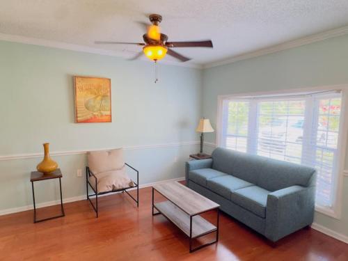 a living room with a couch and a ceiling fan at Sunlit Hideaway 3BR 2BA house pool in Little River