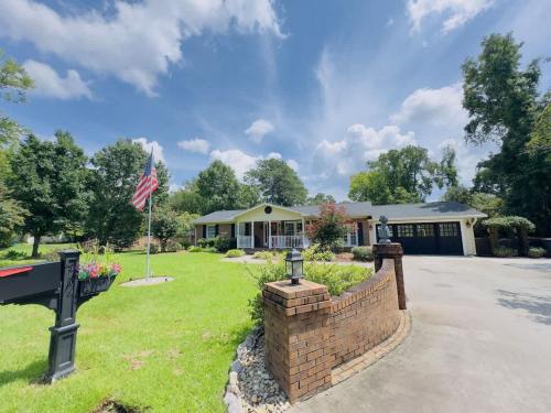 a house with an american flag in the yard at Sunlit Hideaway 3BR 2BA house pool in Little River