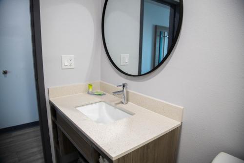 a bathroom with a sink and a mirror at Pico Rivera Inn and Suites in Pico Rivera