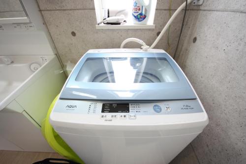 a washing machine in a small room with a washing machine at 海まで徒歩3分の星降るやんばるテラスは1棟貸で古宇利島まで車で10分 in Nago