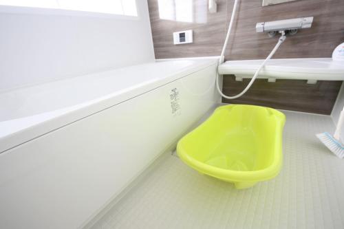 a bathroom with a yellow toilet and a sink at 海まで徒歩3分の星降るやんばるテラスは1棟貸で古宇利島まで車で10分 in Nago