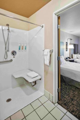 a bathroom with a shower with a toilet and a bed at Grande Denali Lodge by Aspen Hotels in McKinley Park