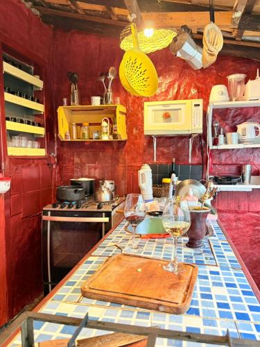 a kitchen with two wine glasses on a counter at Hostel Pantera do Rosa in Praia do Rosa