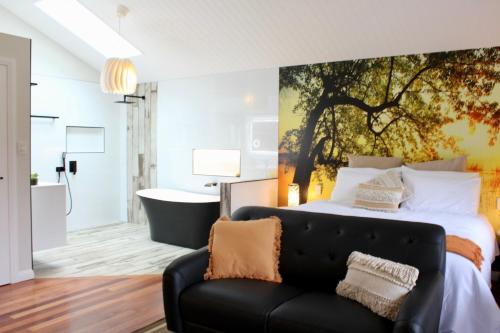 a bedroom with a large bed and a couch at Hideaway Falls - Bunya Cottage in Mapleton