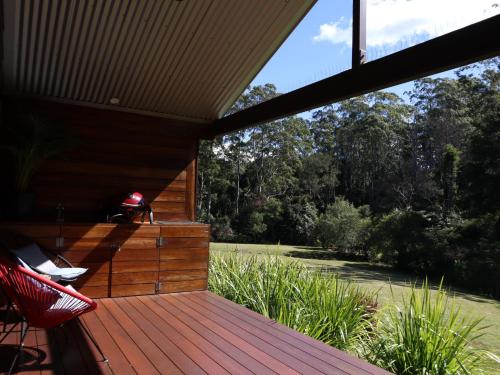a porch of a house with a wooden deck at Hideaway Falls - Bunya Cottage in Mapleton