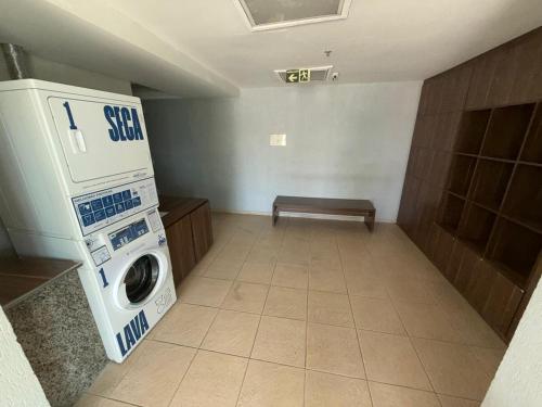 a laundry room with a washing machine and a bench at Flat Studio - Hotel Style in Nova Iguaçu