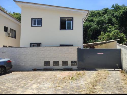 弗洛里亚诺波利斯Studio próximo ao Shopping Floripa的一座白色的房子，前面有大门