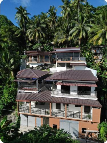 サマルにあるEagles Nest Beach Resort Room 4のヤシの木を背景にした建物の画像
