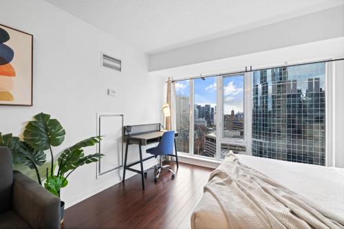a bedroom with a bed and a desk and a window at Cozy Urban Retreat Walk to Yonge-Dundas Square in Toronto