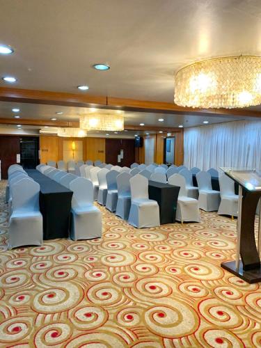 a conference room with white chairs and tables and a chandelier at Goldberry Suites & Hotel Mactan in Mactan