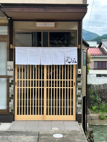 a building with a gate in front of it at River front Guest House 風 in Gujo