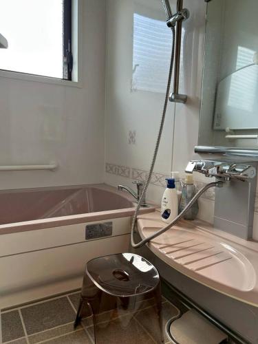 a bathroom with a sink and a tub and a stool at River front Guest House 風 in Gujo