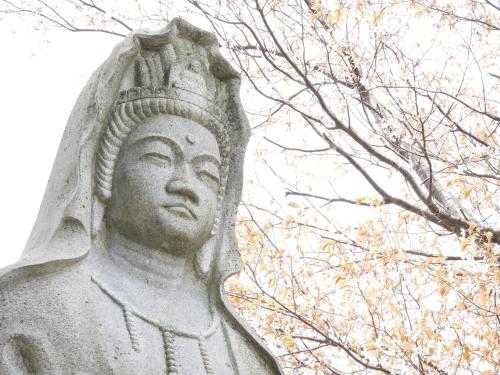 a statue of a man standing next to a tree at せせらぎの宿吉野屋 in Nishiwaga