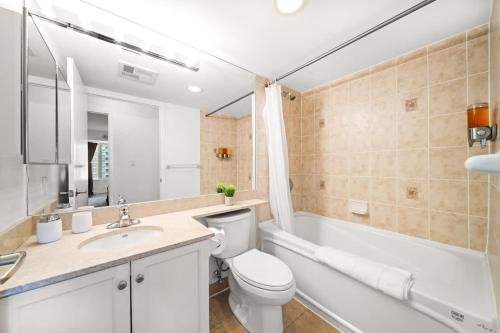 La salle de bains est pourvue de toilettes, d'un lavabo et d'une baignoire. dans l'établissement Chic 1BR Downtown Getaway w King Bed, à Toronto