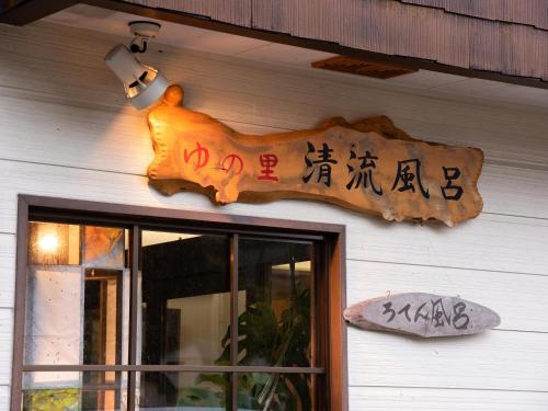 a sign on the side of a building with writing on it at せせらぎの宿吉野屋 in Nishiwaga