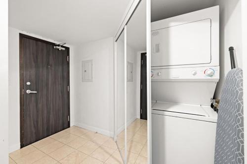 a kitchen with a refrigerator next to a door at Yonge and Dun condo in Toronto