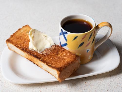 a plate with a piece of toast and a cup of coffee at せせらぎの宿吉野屋 in Nishiwaga