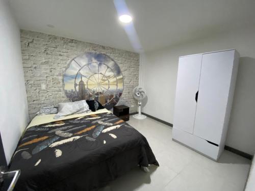 a bedroom with a bed and a brick wall at La Casa Amarilla in Medellín