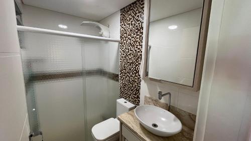 Un baño con inodoro, lavabo y ducha. en Casa com Piscina e Jacuzzi, en Foz do Iguaçu