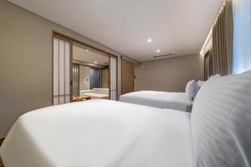 a hotel room with two beds and a window at Hotel Foret The Spa in Busan