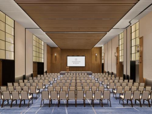 a lecture hall with rows of chairs and a screen at Sheraton Kunshan Dianshan Lake in Kunshan
