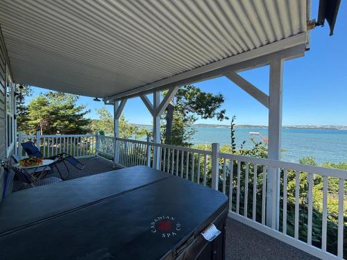 a porch with a table and a view of the water at Entire Cozy Apartment with Share Jacuzzi to Enjoy Amazing Views in Halifax