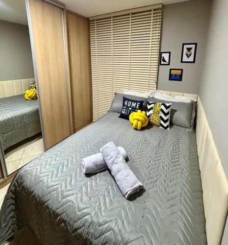 a bedroom with a large bed with towels on it at Casa Confortável 03 Quartos Com Suite, Churrasqueira, Banheira e Garagem in Curitiba