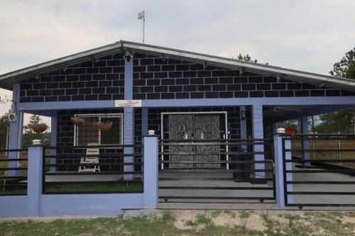 ein blaues Gebäude mit einer Veranda und einem Tor in der Unterkunft One Wish in Siguatepeque