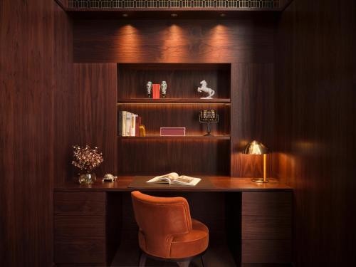 a desk with a chair and a book shelf at Rosewood Vienna in Vienna