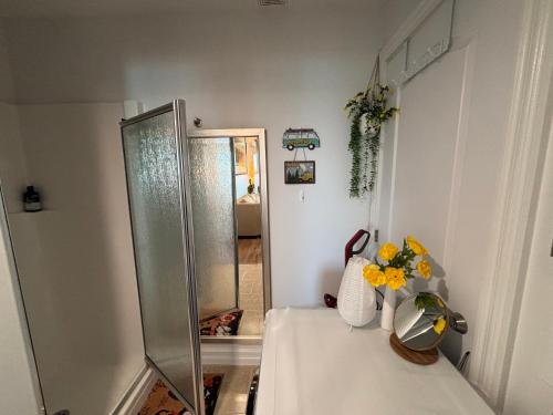 a bathroom with a shower and a table with flowers on it at Entire Cozy Apartment with Share Jacuzzi to Enjoy Amazing Views in Halifax
