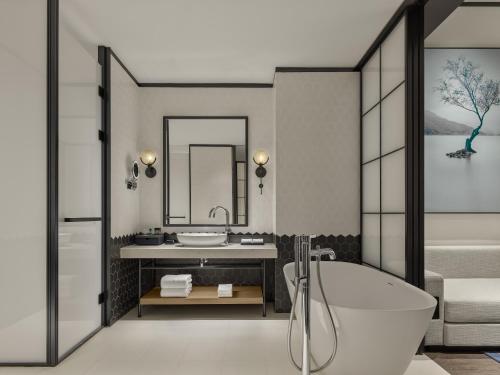 a bathroom with a tub and a sink at Sheraton Kunshan Dianshan Lake in Kunshan