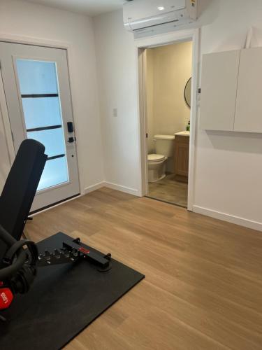 een kamer met een fitnessruimte met een loopband en een badkamer bij Garden Suite with Pool and Sauna in Brampton