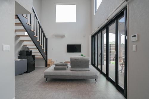 a living room with a chair and a television at 新築オーシャンビュー離れ FLAG Awaji HANARE in Awaji