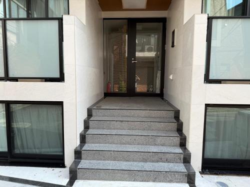 a staircase leading to a building with glass doors at さくら旅館高円寺北千利休201号室 in Tokyo