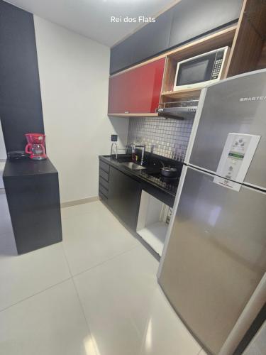 a small kitchen with a counter and a refrigerator at Flat Nobile Suítes Monumental By Rei dos Flats, in Brasilia