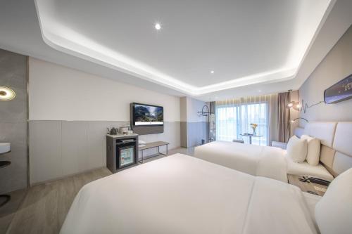 a hotel room with a bed and a tv at Atour Light Hotel Chengdu Dujiangyan in Dujiangyan