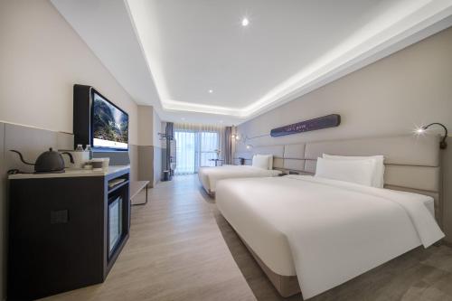 a hotel room with two beds and a flat screen tv at Atour Light Hotel Chengdu Dujiangyan in Dujiangyan
